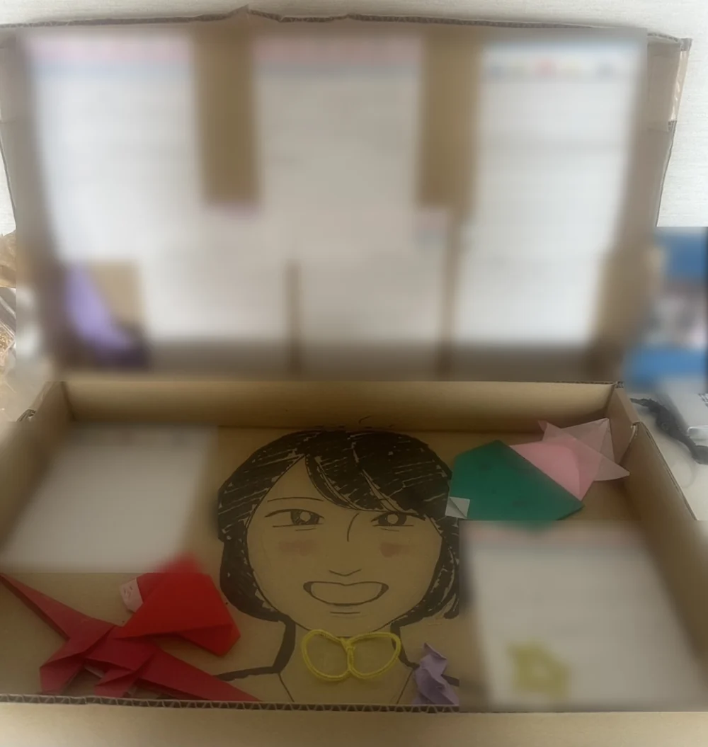 学園の子どもたちから届いた箱。駒子さんの似顔絵と、折り紙と、手紙が入っている